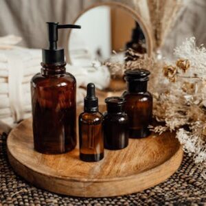 Modern still life with amber glass bottles on a wooden tray, evoking a serene, natural atmosphere.